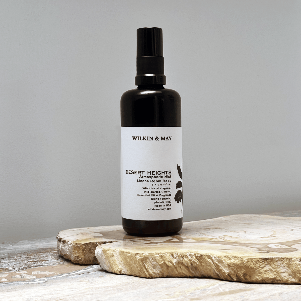 Black spray bottle with white label against a grey background