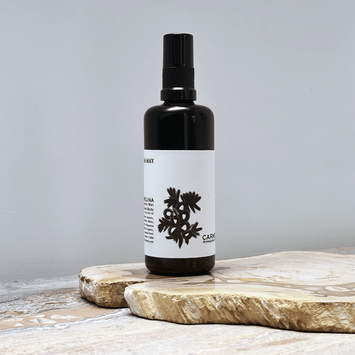 Black spray bottle with a white label on a wooden surface