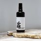 Black spray bottle with white label against a gray background