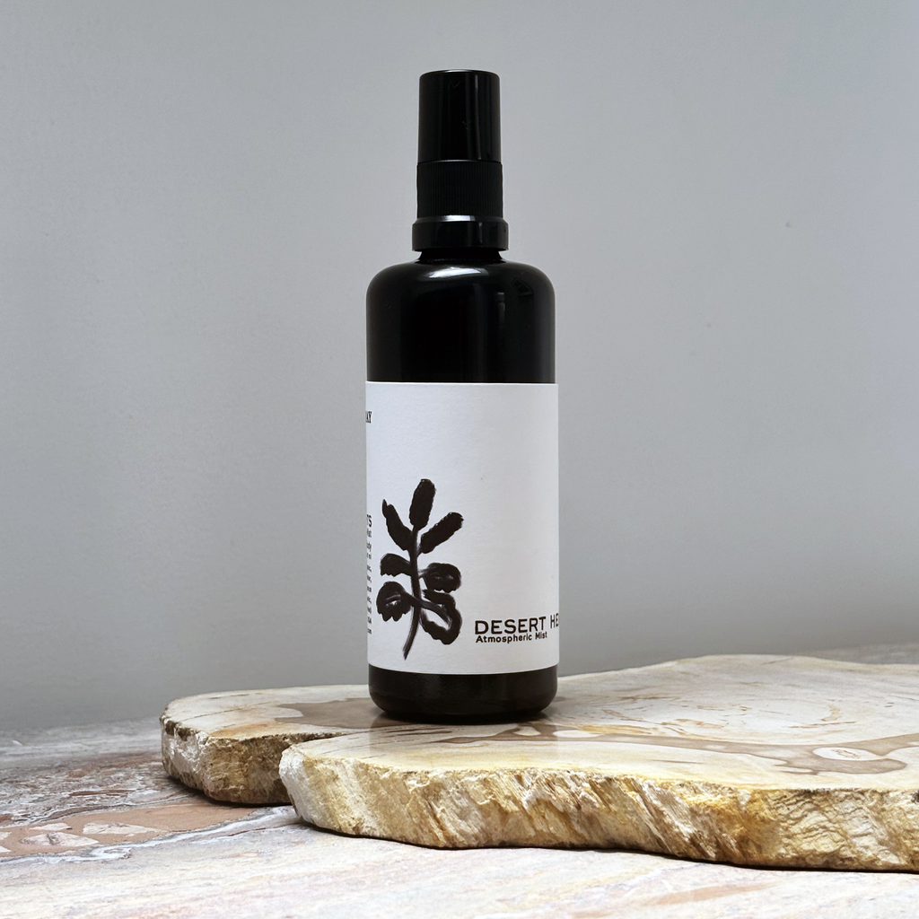 Black spray bottle with white label against a gray background
