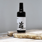 Black spray bottle with white label against a grey background