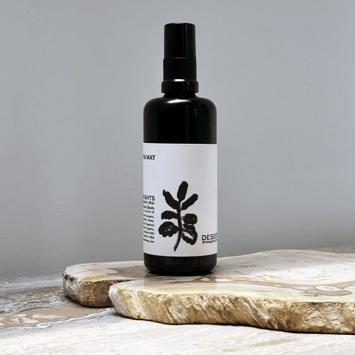 Black spray bottle with white label against a grey background