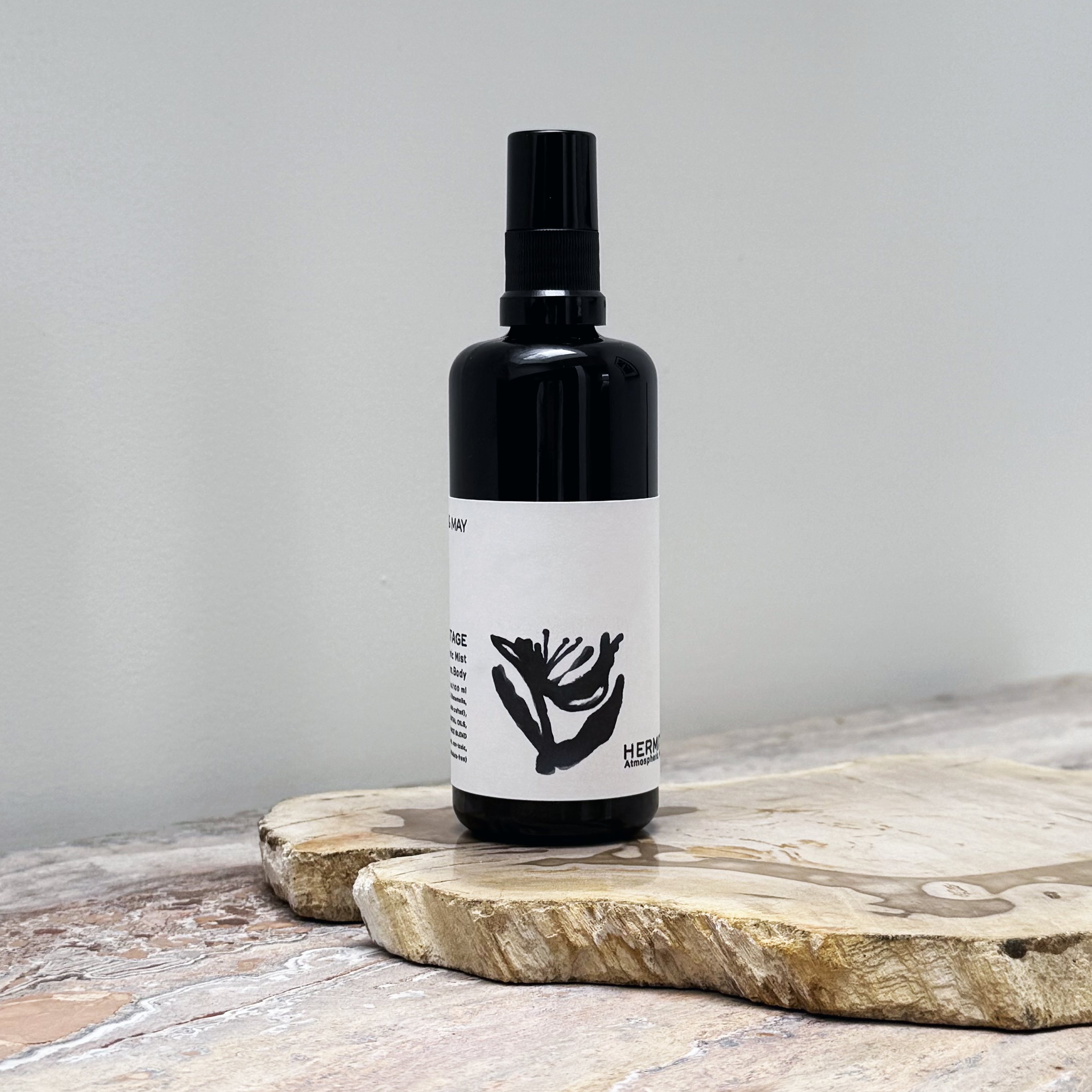 Black spray bottle with a white label on a wooden surface
