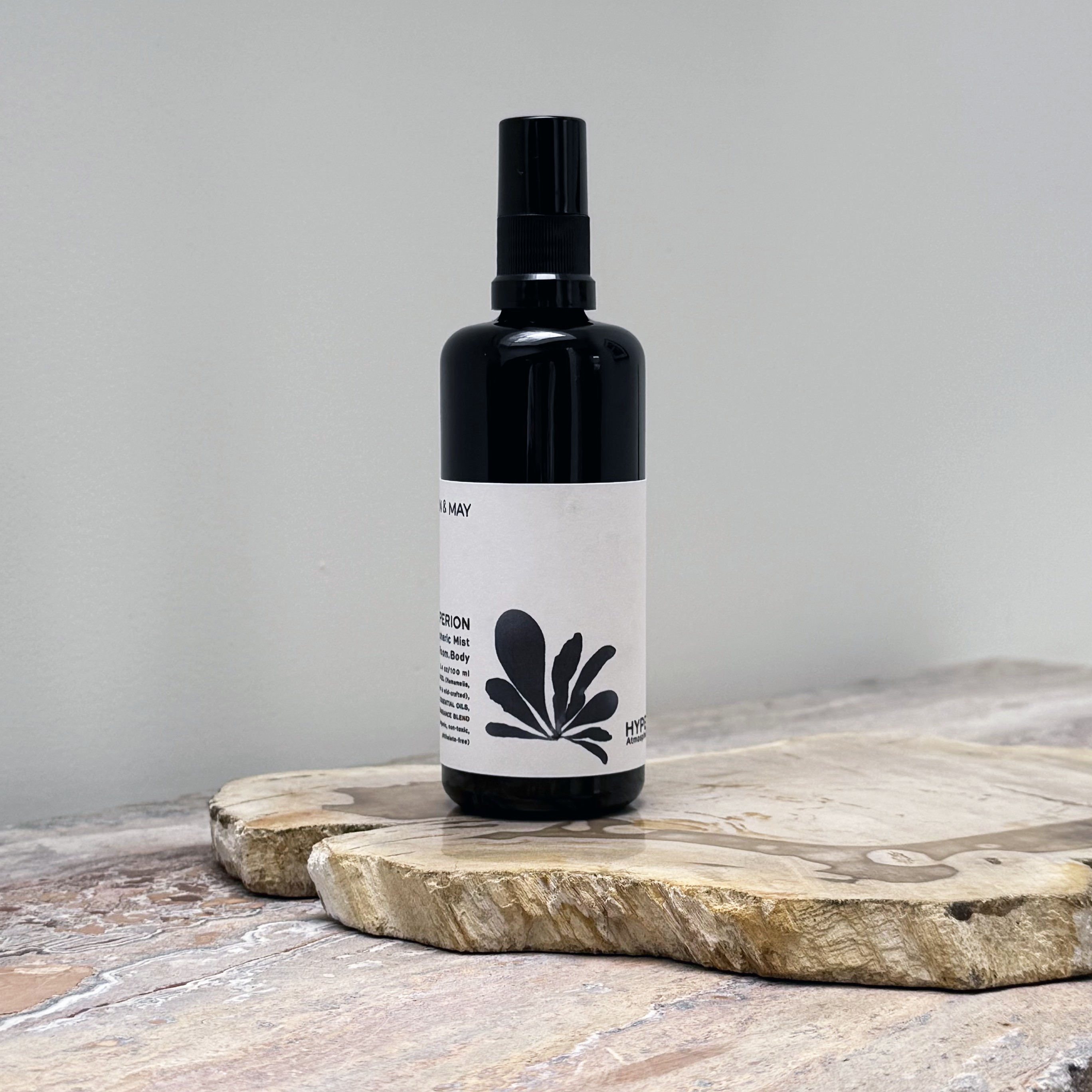 Black spray bottle with a white label on a wooden surface