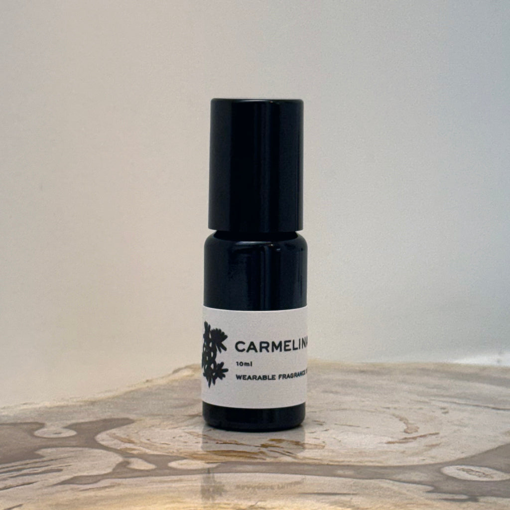 Black perfume bottle with a white label on a marble surface
