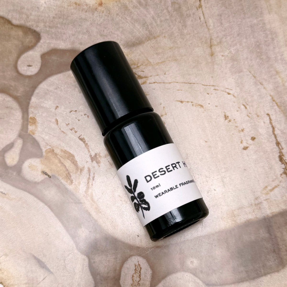 Desert Heights perfume bottle on a textured beige surface