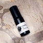 Black and white bottle labeled 'Laurel' on a textured beige background