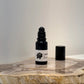 Black roller bottle with a white label on a marble surface