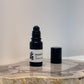 opened Black Roller bottle with white label sitting beside lid on wood surface