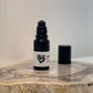 black opened bottle of Hermitage fragrance oil roller on a wooden surface