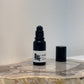 Black roller bottle with a white label on a marble surface